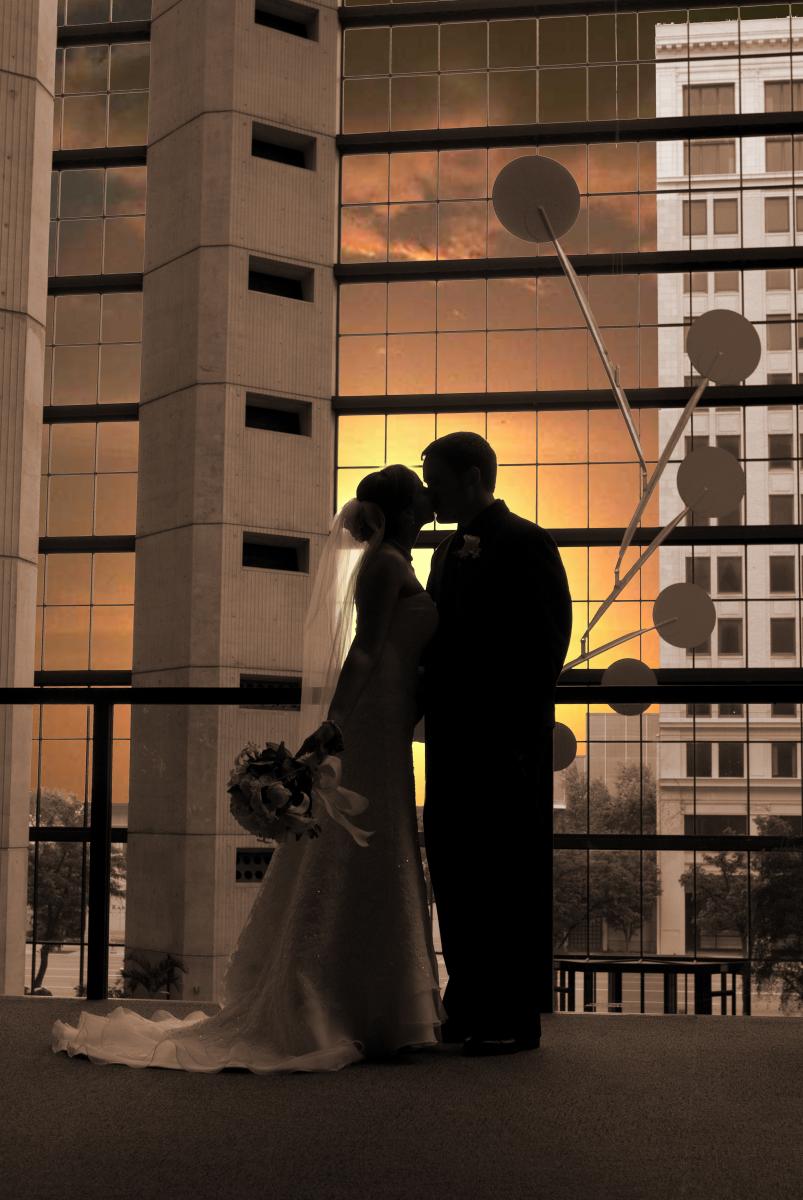 Feelings of passion dramatized by a couple silhouetted against a vibrant sunset, by Robertsons' Warehouse Photography, Wichita, KS