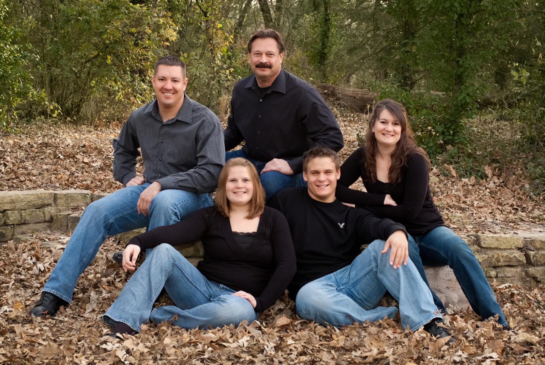 The Haskins family scheduled their sitting for early fall; even though the foreground was blanketed with oak leaves, the far background was still lush with green vegetation, by Robertsons' Warehouse Photography, Wichita, KS